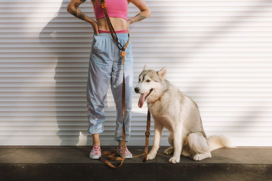 Woman in casual attire standing with her Siberian Husky dog by a roller shutter.